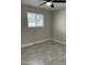 This bedroom has a window, gray flooring, and a ceiling fan at 845 N Los Alamos Dr, Goodyear, AZ 85338