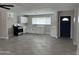 Open concept kitchen and living area featuring tile flooring, quartz counters, and new appliances at 845 N Los Alamos Dr, Goodyear, AZ 85338