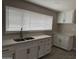 Bright kitchen featuring quartz counters, stainless steel sink, and plentiful white cabinetry at 845 N Los Alamos Dr, Goodyear, AZ 85338