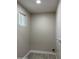 Neutral laundry room with light-colored walls, modern flooring and natural light from a window at 845 N Los Alamos Dr, Goodyear, AZ 85338