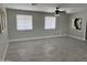 Bright living room featuring tile floors, two windows, a ceiling fan, and neutral paint at 845 N Los Alamos Dr, Goodyear, AZ 85338