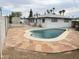 Backyard features a refreshing pool with a unique shape, complemented by stone tile and a secure surrounding fence at 845 N Los Alamos Dr, Goodyear, AZ 85338