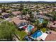 Backyard oasis with a sparkling pool, patio area, mature trees, and lush landscaping. Community view at 9012 E Sutton Dr, Scottsdale, AZ 85260