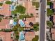 Aerial view of neighborhood featuring homes with pools, tile roofs, green lawns, and mature landscaping at 9012 E Sutton Dr, Scottsdale, AZ 85260