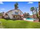 Spacious backyard with lush green lawn, covered patio, pool, spa, and outdoor seating at 9012 E Sutton Dr, Scottsdale, AZ 85260