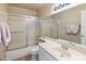 Bright bathroom features a shower-tub combination with sliding glass doors, and a stylish sink and vanity at 9012 E Sutton Dr, Scottsdale, AZ 85260