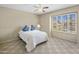 A cozy bedroom with a ceiling fan, natural light from a large window, and neutral carpet at 9012 E Sutton Dr, Scottsdale, AZ 85260