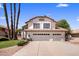 Two-story home with a three-car garage, well-maintained landscaping, and mature palm trees against a blue sky at 9012 E Sutton Dr, Scottsdale, AZ 85260