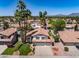 Charming two-story home featuring a tile roof, well-manicured lawn, and a three-car garage, complemented by mature palm trees at 9012 E Sutton Dr, Scottsdale, AZ 85260