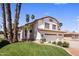 Charming two-story home with a three-car garage, manicured lawn, and beautiful palm trees at 9012 E Sutton Dr, Scottsdale, AZ 85260