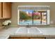 Kitchen sink beneath window with view of the lush backyard and inviting pool at 9012 E Sutton Dr, Scottsdale, AZ 85260