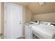 A well-lit laundry room featuring side-by-side washer and dryer units with an exterior door to the outside at 9012 E Sutton Dr, Scottsdale, AZ 85260