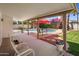 Covered patio featuring outdoor seating, red umbrellas, lush greenery, and a view of the pool at 9012 E Sutton Dr, Scottsdale, AZ 85260
