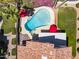 View of backyard pool with red umbrella and lush landscaping. Pool also includes spa at 9012 E Sutton Dr, Scottsdale, AZ 85260