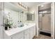 Bathroom with white cabinetry, a large mirror, a glass-enclosed shower, and modern fixtures at 9028 W Osborn Rd, Phoenix, AZ 85037