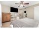 Bedroom with carpet, a ceiling fan, a desk, an armoire, and a large TV at 9028 W Osborn Rd, Phoenix, AZ 85037