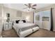 Comfortable bedroom with neutral tones, carpet, ceiling fan, and a large window at 9028 W Osborn Rd, Phoenix, AZ 85037