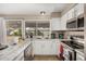 Bright kitchen featuring stainless steel appliances, white cabinets, stone countertops, and a view to the backyard at 9028 W Osborn Rd, Phoenix, AZ 85037