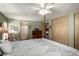 The primary bedroom features a ceiling fan, a washing machine and closet with a sliding wood door at 9333 E University Dr # 83, Mesa, AZ 85207