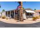 Charming manufactured home with desert landscaping, covered porch and an American flag on a palm tree at 9333 E University Dr # 83, Mesa, AZ 85207