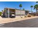 Well-maintained home featuring desert landscaping, awnings, and a covered carport for convenience at 9333 E University Dr # 83, Mesa, AZ 85207
