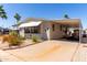 Well-maintained home featuring a covered parking area, lush greenery, and desert-friendly landscape at 9333 E University Dr # 83, Mesa, AZ 85207