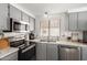 Updated kitchen features stainless steel appliances, modern lighting, and tile backsplash at 9333 E University Dr # 83, Mesa, AZ 85207