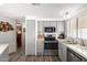 Galley-style kitchen with stainless steel appliances, modern lighting, and granite countertops at 9333 E University Dr # 83, Mesa, AZ 85207