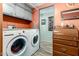 Organized laundry room with appliances, storage cabinets, and a vintage rolltop desk at 9333 E University Dr # 83, Mesa, AZ 85207