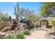Inviting entryway featuring a rock waterfall feature and native desert landscaping at 11334 E Troon Vista Dr, Scottsdale, AZ 85255
