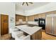 Bright kitchen with light wood cabinets, marble countertops, a large island with seating, and modern appliances at 11334 E Troon Vista Dr, Scottsdale, AZ 85255