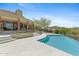 Stunning backyard with a luxurious swimming pool, desert landscaping, and a covered patio for entertaining guests at 11334 E Troon Vista Dr, Scottsdale, AZ 85255