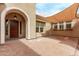 Spacious outdoor courtyard with paved brick, overhead sunshade, and elegant archway entrance at 12906 W Oyer Ln, Peoria, AZ 85383