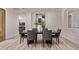 Light-filled dining room with dark wood table, seating for eight, and light wood floors at 12906 W Oyer Ln, Peoria, AZ 85383