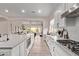 A gourmet kitchen featuring white cabinets, a large island, and an open design to the living area at 12906 W Oyer Ln, Peoria, AZ 85383