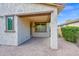 A covered back patio features brick pavers and beige columns and trim, seamlessly blending indoor/outdoor living at 134 E Bernie Ln, Gilbert, AZ 85295