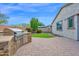 Outdoor kitchen with a stainless steel grill, drawers, stone counter, and a lush, easy-care synthetic lawn at 134 E Bernie Ln, Gilbert, AZ 85295