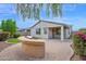 An outdoor kitchen sits on a paver patio, with verdant landscaping and clear skies providing privacy at 134 E Bernie Ln, Gilbert, AZ 85295