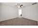 Carpeted bedroom featuring a ceiling fan and a view to the bathroom at 134 E Bernie Ln, Gilbert, AZ 85295