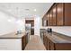 Open concept kitchen with dark cabinets, granite counters and stainless appliances at 134 E Bernie Ln, Gilbert, AZ 85295