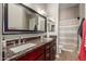 Bathroom with dual sinks, granite countertops, wood cabinets, and a shower-tub combo at 1367 S Country Club Dr # 1039, Mesa, AZ 85210
