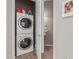 This laundry room features a stacked washer and dryer with a nearby powder room and sink at 1367 S Country Club Dr # 1039, Mesa, AZ 85210