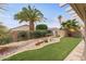 Inviting backyard featuring artificial turf, desert landscaping, and a gravel drainage feature, perfect for outdoor enjoyment at 16205 W Mountain Pass Dr, Surprise, AZ 85374
