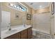 Bathroom with double sinks, a large mirror, and a shower with glass doors at 16205 W Mountain Pass Dr, Surprise, AZ 85374