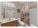 Bathroom featuring a light wood vanity and tub with southwestern themed shower curtain at 16205 W Mountain Pass Dr, Surprise, AZ 85374