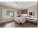 Bright bedroom featuring wood floors, a ceiling fan, and a window with backyard views at 16205 W Mountain Pass Dr, Surprise, AZ 85374