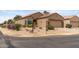 Single-story house on a corner lot with a two-car garage, desert landscaping, and street signs at 16205 W Mountain Pass Dr, Surprise, AZ 85374