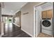 Open-concept hallway displaying dark wood floors and a laundry room to the side at 16205 W Mountain Pass Dr, Surprise, AZ 85374