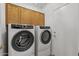 Laundry room features front loading washer and dryer plus upper cabinets at 16205 W Mountain Pass Dr, Surprise, AZ 85374