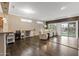 Open concept living room area with dark wood floors, ceiling fan, and sliding glass doors at 16205 W Mountain Pass Dr, Surprise, AZ 85374